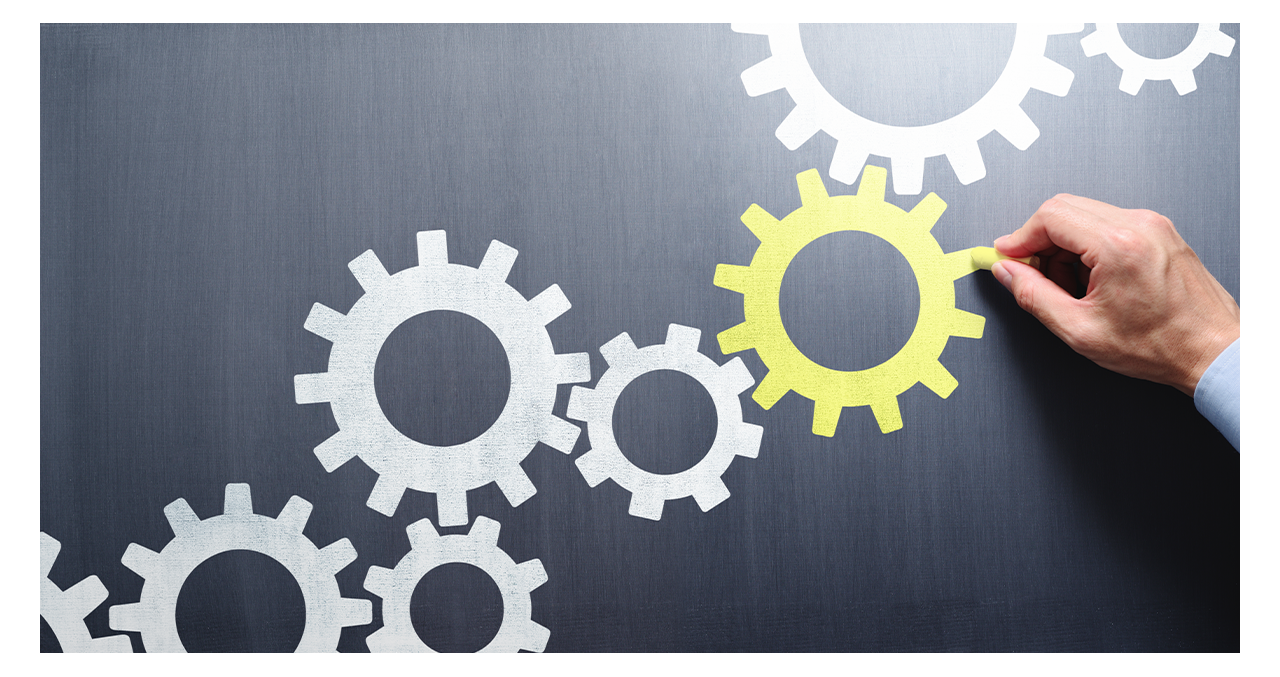 Abstract image of white gears with yellow gear highlighted